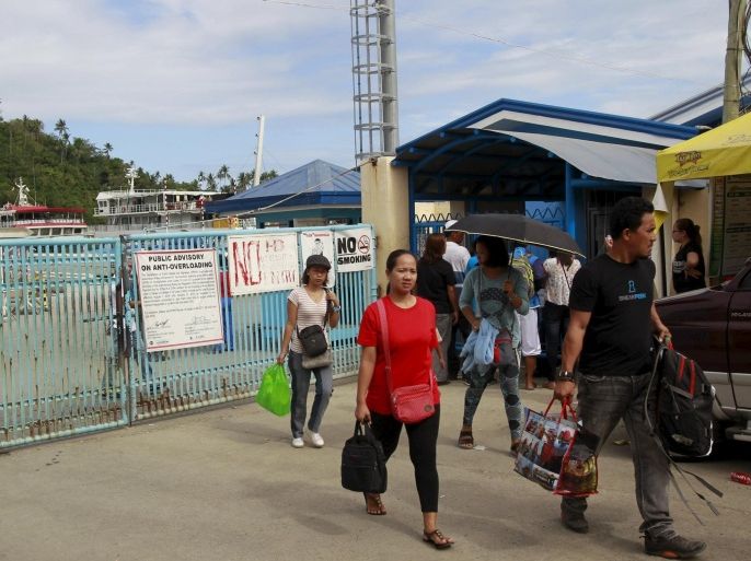 Stranded passengers leave the port after learning that ferry services were stopped in preparation for an approaching storm in Marinduque island, central Philippines April 4, 2015. Typhoon Maysak was losing strength as it approached Aurora province, but was still expected to bring strong winds and dump heavy rains when it crosses northern areas of the main Luzon island on Sunday, the state weather bureau said. REUTERS/Romeo Ranoco