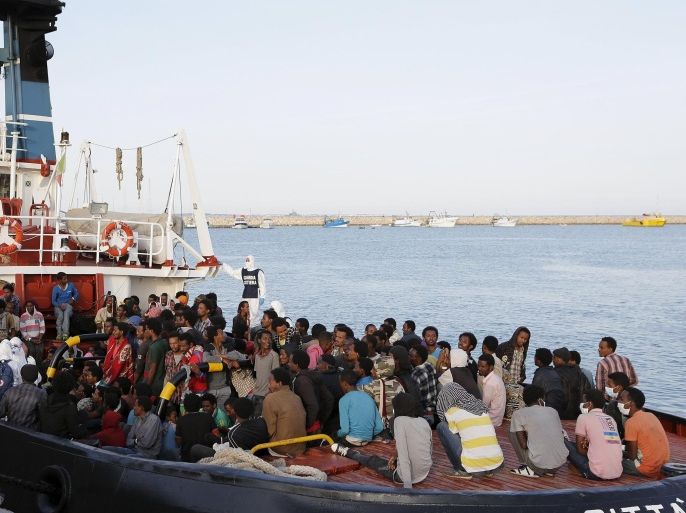 Migrants wait to disembark in the Sicilian harbour of Augusta, Italy, May 30, 2015. Close to 1,000 migrants rescued in on-going operations are brought safely to port in Sicily as Italian authorities say over 4,000 migrants have been saved from the Mediterranean in twenty-four hours and 17 migrants have been found dead on a boat. REUTERS/Antonio Parrinello