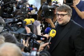 Guillermo Del Toro, right, speaks to members of the media as he arrives at a hotel ahead of the 68th international film festival, Cannes, southern France, Tuesday, May 12, 2015. The festival opens on Wednesday, May 13 and runs until Sunday, May 24. (AP Photo/Thibault Camus)