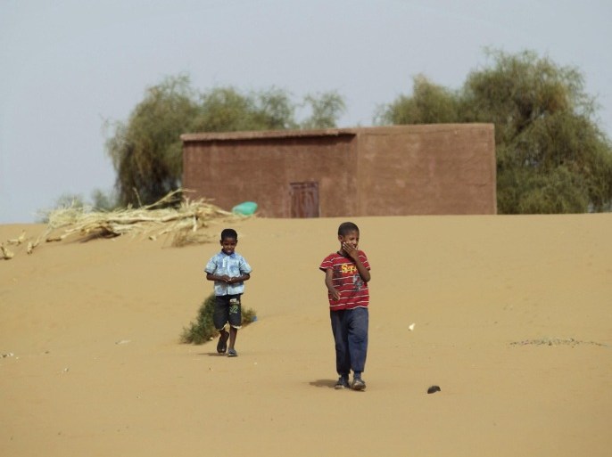 Boys walk on desert sands in the town of Moghtar-Lajjar May 25 2012. Civil unrest and a drought in west Africa's Sahel region have put 15 million people in food insecurity, according to the United Nations. REUTERS/Joe Penney (MAURITANIA - Tags: SOCIETY)