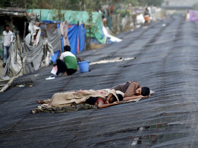 عمال ينامون فوق أسطح الأكواخ جراء الحرفي نيودلهي (رويترز)