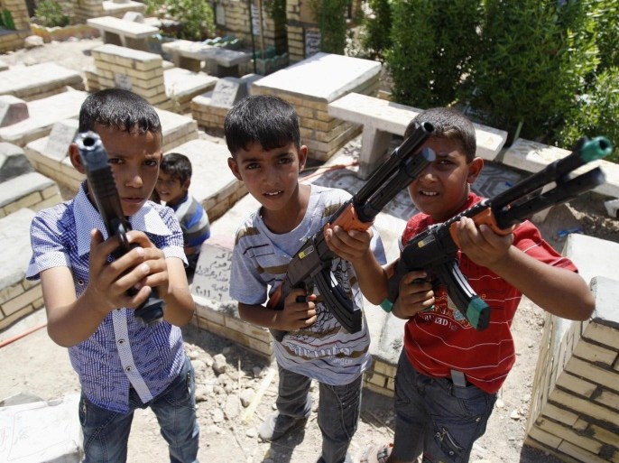 Iraqi boys pose with toy guns during a family visit to the grave of a relative in a cemetery in Basra, 420 km (260 miles) south of Baghdad September 1, 2011. Picture taken September 1, 2011.