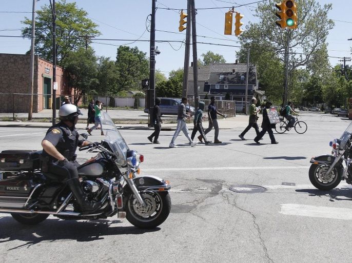 Cleveland police officers look on as protesters march through the streets blocking traffic in Cleveland, Ohio, USA, 23 May 2015 following the anouncement of a not guilty verdict for Cleveland Police officer Michael Brelo who was on trial for manslaughter in the shooting deaths of an unarmed black man and woman following a high speed car chase in 2012.