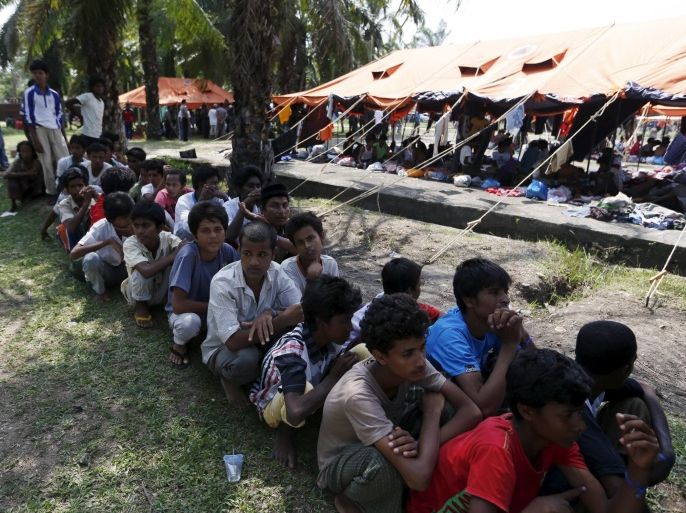 Rohingya migrants, who recently arrived in Indonesia by boat, queue up as they wait to have their identification recorded inside a temporary compound for refugees in Aceh Timur regency, Indonesia's Aceh Province May 21, 2015. Malaysia and Indonesia issued a joint statement on Wednesday saying they will continue to offer international assistance to 7,000 migrants adrift at sea and assist them with "resettlement and repatriation" within a year with international help. REUTERS/Beawiharta