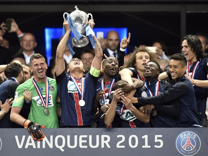 Paris Saint-Germain's Brazilian defender Thiago Silva holds up the trophy as Paris Saint-Germain's players celebrate after winning the French Cup final football match against Auxerre at the Stade de France stadium in Saint-Denis, north of Paris, on May 30, 2015. AFP PHOTO / FRANCK FIFE