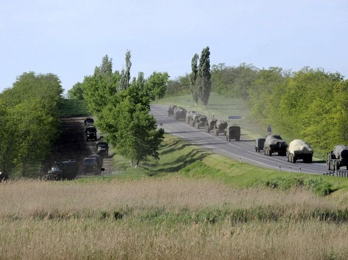 Military vehicles drive along a road at the Russian southern town of Matveev Kurgan, near the Russian-Ukrainian border in Rostov region, Russia, May 24, 2015. Picture taken May 24, 2015. REUTERS/Stringer TO MATCH UKRAINE-CRISIS/RUSSIA-MILITARY