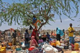 Somali refugees stand amongst their scattered belongings after their temporary shelters were destroyed by Somali soldiers on March 4, 2015 at the Sarkusta refugee camp in southern Mogadishu. Dozens of houses and shops were destroyed in the area after the Somali government ordered the demolition of makeshift homes. AFP PHOTO / Mohamed Abdiwahab