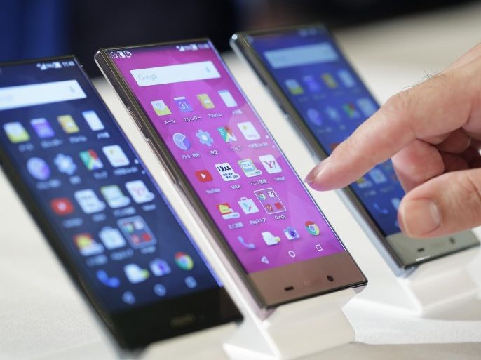 SoftBank Corp. Aquos Crystal2 smartphones, manufactured by Sharp Corp., sit on display during a product launch in Tokyo, Japan, on Tuesday, May 19, 2015. SoftBank's Japanese mobile business added a net 1.8 million subscribers in the year ended March bringing the total to 37.77 million, the company reported last week.