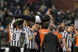 Juventus' players celebrate with their coach Massimiliano Allegri after winning the 'Scudetto' at the end of the Italian Serie A football match Sampdoria Vs Juventus on May 2, 2015 at 'Luigi Ferraris Stadium' in Genoa. Juventus won 1-0. AFP PHOTO / ANDREAS SOLARO