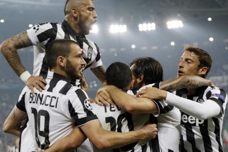 Juventus' Carlos Tevez, third from left, celebrates with his teammates, from left, Arturo Vidal, top, Leonardo Bonucci, Andrea Pirlo and Claudio Marchisio after scoring, during the Champions League, semifinal soccer match between Juventus and Real Madrid at the Juventus Stadium in Turin, Italy, Tuesday, May 5, 2015. Juventus won 2-1. (AP Photo/Luca Bruno)