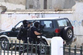 A Tunisian anti-terrorism brigade officer aims his weapon as he arrives with his comrade to take position after a shooting at the Bouchoucha military base in Tunis, Tunisia May 25, 2015. A Tunisian soldier opened fire on colleagues at a military base in the capital Tunis on Monday, killing a colonel and wounding eight other soldiers before he was shot dead himself, an army spokesman and a security source said. REUTERS/Zoubeir Souissi