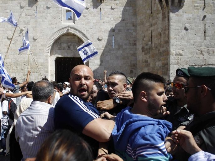 JERUSALEM - MAY 17: A group of Jewish settlers provoke Palestinians as they march into Al-Aqsa Mosque compound in occupied East Jerusalem as they mark 'Jerusalem Day' in Jerusalem on May 17, 2015. Israelis celebrates 17th of May as Jerusalem Day to mark their invasion of east Jerusalem anniversary occurred on the year 1967.