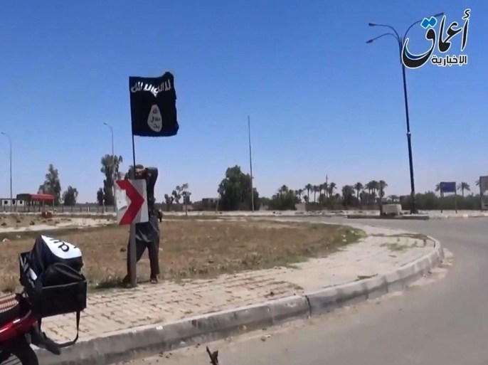 A photograph made from a video released by the jihadist affiliated group Aamaq Media on 18 May 2015 purportedly to show an alleged Islamic State (IS) fighter placing the group's flag on a road sign in the city of Ramadi, 110 kilometres west of Baghdad, Iraq. Reports on 16 May said Islamic State militants have assumed control of most of Ramadi, the capital city of west Iraq's Anbar province, marking a major advance for the extremist militia. Islamic State's advance into Ramadi deals a major setback to Iraqi government efforts to drive the radical group out of the country. EPA/AAMAQ MEDIA / HANDOUT ATTENTION EDITORS : EPA IS USING AN IMAGE FROM AN ALTERNATIVE SOURCE AND CANNOT PROVIDE CONFIRMATION OF CONTENT, AUTHENTICITY, PLACE, DATE AND SOURCE. HANDOUT EDITORIAL USE ONLY/NO SALES