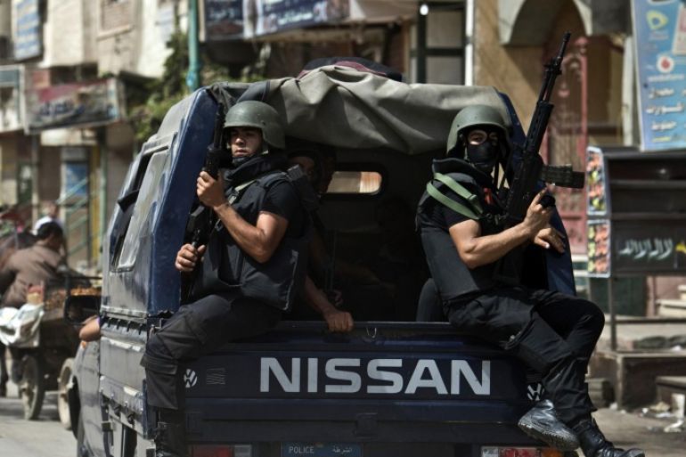 Egyptian armed policemen sit at the back of a truck as they patrol the village of Kerdassah in the district of Giza, on the outskirts of Cairo, on September 19, 2013. A police general was killed when Egyptian security forces stormed Kerdassah in the latest crackdown on Islamist militants, security officials said.