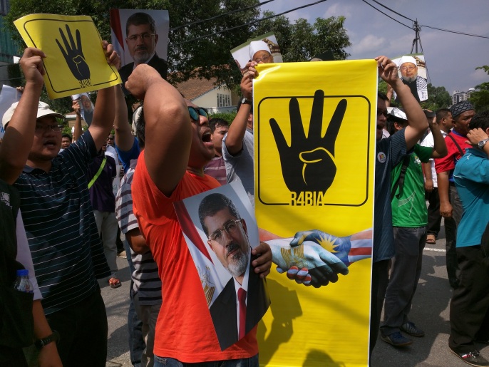 متظاهرون يحملون رسالة تضامن ماليزية مع الشعب المصري والقيادات السياسية المعتقلة (الجزيرة نت)