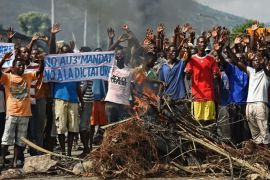 Protestors raise their hands behind a barricade during a demonstration in the Musaga neighborhood of Bujumbura on May 18, 2015. Protesters opposed to Burundi President Pierre Nkurunziza launched fresh demonstrations, resuming weeks of street marches after a failed coup despite warnings from the government. Opposition and rights groups insist that Nkurunziza's bid for a third five-year term is against the constitution and the terms of the peace deal that brought an end to the country's civil war in 2006. AFP PHOTO / CARL DE SOUZA