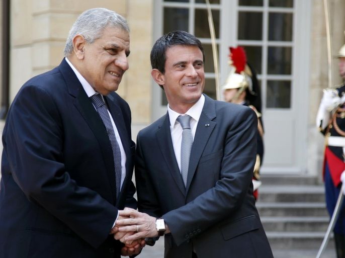 REFILE - CORRECTING TYPO IN DATE Egyptian Prime Minister Ibrahim Mehleb (L) is greeted by French Prime Minister Manuel Valls (C) as he arrives at the Hotel Matignon in Paris, France May 13, 2015. REUTERS/Charles Platiau