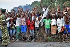 Protestors cheer in front of a barricade during a demonstration against Burundian President's third term candidature in the Cibitoke neighborhood of Bujumbura on May 22, 2015. Thousands of anti-government protesters in Burundi marched on the streets of the capital Bujumbura, defying one of the heaviest pushes by police to end weeks of demonstrations. AFP PHOTO/ CARL DE SOUZA
