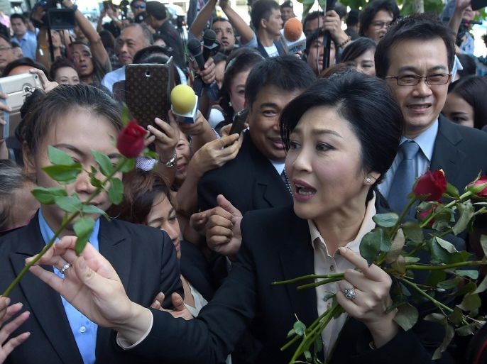 Thailand's former premier Yingluck Shinawatra receives roses from her supporters outside the Supreme Court in Bangkok on May 19, 2015. Thailand's first female prime minister Yingluck faced court at the start of a negligence trial which could see her jailed for a decade and deliver a hammer blow to the political dominance of her family. AFP PHOTO / PORNCHAI KITTIWONGSAKUL