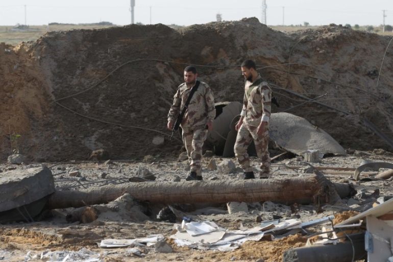 Palestinian security men walk amidst debris following an Israeli airstrike in the southern Gaza Strip near the town, of Rafah on May 27,2015. The Israeli air force carried out four strikes on militant targets in the Gaza Strip early today, Palestinian eyewitnesses said, hours after a cross-border rocket attack on the Jewish state. The planes targeted training camps belonging to the Islamic Jihad in Rafah, Khan Yunis and Gaza City, the witnesses said. There were no immediate reports of casualties. AFP PHOTO/ SAID KHATIB