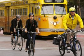 Cyclists ride with a street car in the Mid Market neighborhood during Bike to Work Day in San Francisco, California May 14, 2015. REUTERS/Robert Galbraith