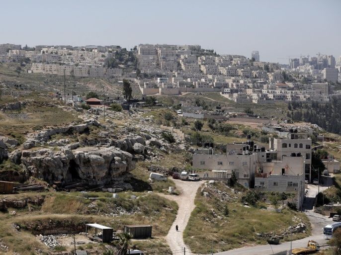Backdropped by a view of Ramat Shlomo, a Jewish settlement in the mainly Arab eastern sector of Jerusalem, Palestinian houses are seen from the East Jerusalem neighborhood of Beit Hanina, on May 6, 2015. Israel has approved construction of 900 settler homes in the east Jerusalem settlement neighbourhood of Ramat Shlomo, an NGO said on May 7, 2015 shortly after Prime Minister Benjamin Netanyahu formed a new rightwing religious coalition. AFP PHOTO / AHMAD GHARABLI