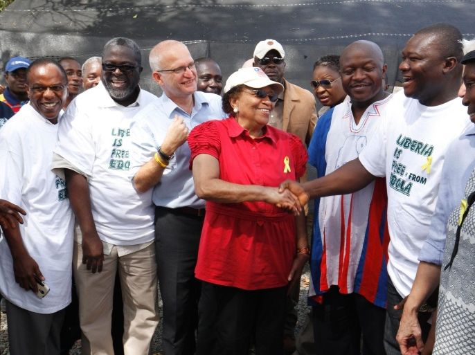 epaselect epa04740107 Liberia's President Ellen Johnson Sirleaf (C) shakes hands with Tolbert Nyenswuah (R), head of Liberia Ebola Response, to mark the end of the Ebola outbreak in Liberia, 09 May 2015. Giving handshakes was rarely practiced as it was one of the measures to prevent the spread of Ebola. The World Health Organization (WHO) on 09 May 2015 officially declared Liberia free from Ebola after no new cases were reported for 42 days, twice the virus' incubation period.