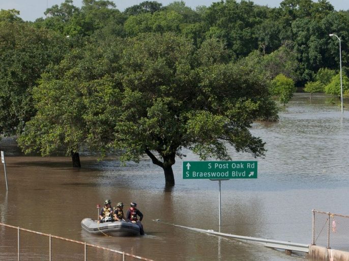 Rescue personnel search the floodwaters along Brays Bayou in southwest Houston, Texas May 26, 2015. Torrential rains have killed at least eight people in Texas and Oklahoma, including two in Houston where flooding turned streets into rivers and led to nearly 1,000 calls for help in the fourth-most populous U.S. city, officials said on Tuesday. REUTERS/Daniel Kramer