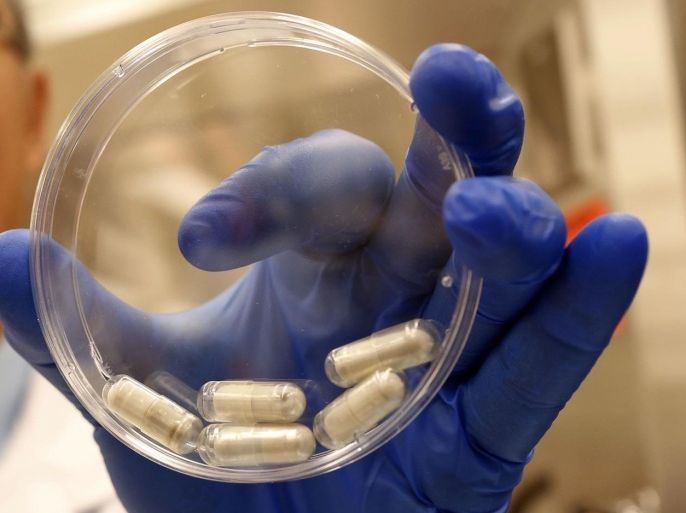 Dr. Thomas Louie, an infectious disease specialist at the University of Calgary, holds a container of stool pills in triple-coated gel capsules in his lab in Calgary, Alberta, Canada on Thursday, Sept. 26, 2013. Half a million Americans get Clostridium difficile, or C-diff, infections each year, and about 14,000 die. A very potent and pricey antibiotic can kill C-diff but also destroys good bacteria that live in the gut, leaving it more susceptible to future infections. Recently, studies have shown that fecal transplants - giving infected people stool from a healthy donor - can restore that balance. (AP Photo/The Canadian Press, Jeff McIntosh)