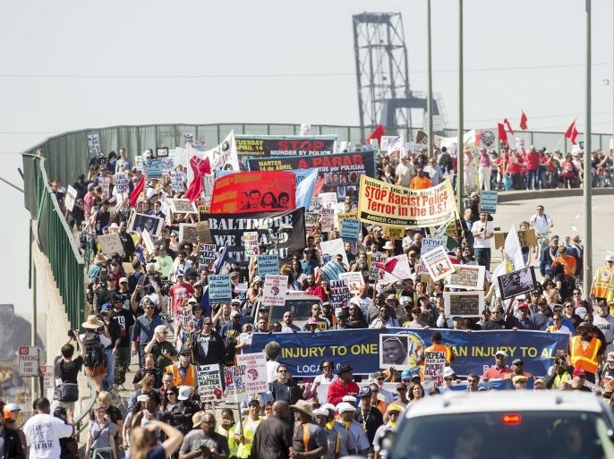 Demonstrators participate in a May Day protest in Oakland, California May 1, 2015. About 300 protesters, bearing signs against police brutality, capitalism and racism, gathered at the Port of Oakland. REUTERS/Noah Berger