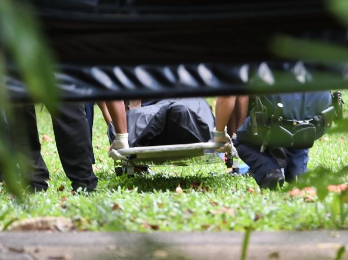 Police officers carry away a gun shot victim in a body bag behind a cordoned area near the Shangri-La hotel where the 14th Asia Security Summit, the International Institute for Strategic Studies (IISS) Shangri-La Dialogue 2015 is being held in Singapore on May 31, 2015. The Asia-Pacific security summit in Singapore was placed under lockdown May 31 after police shot a man dead in an apparent drug-related incident outside the venue, according to a police statement. AFP PHOTO / ROSLAN RAHMAN