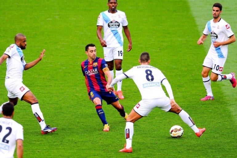 BARCELONA, SPAIN - MAY 23: Xavi Hernandez of FC Barcelona controls the ball among RC Deportivo La Coruna players during the La Liga match between FC Barcelona and RC Deportivo de la Coruna at Camp Nou on May 23, 2015 in Barcelona, Spain.