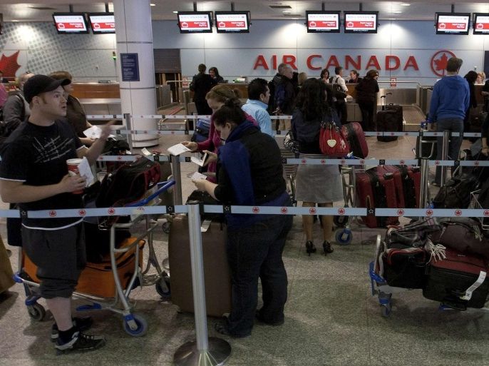Air Canada travellers wait at the check-in area as baggage handlers at Pierre Elliott Trudeau airport walked off the job, causing cancellations and delay, in Montreal March 23, 2012.