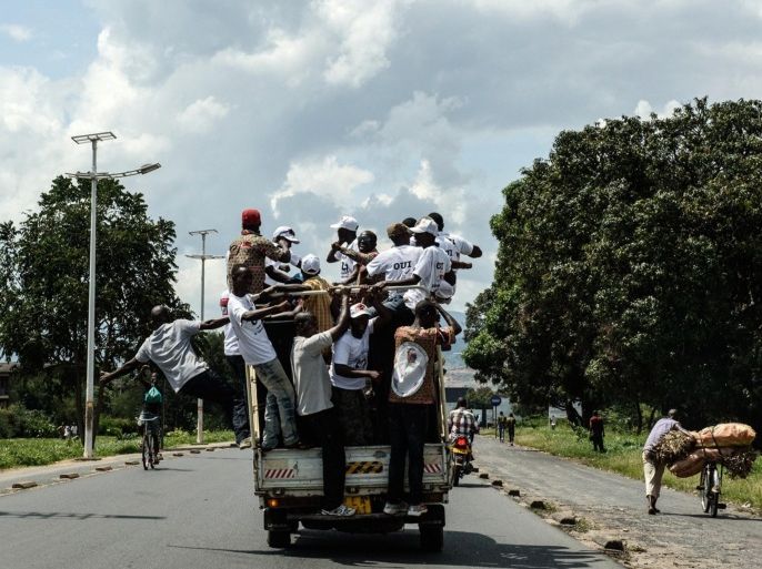 Supporters of Burundi's ruling CNDD-FDD party ride on the back of a truck to promote the party in central Bujumbura on May 15, 2015, a few hours prior to the return of the president in the capital after the failure of a coup attempt by a top general. Burundian President Pierre Nkurunziza thanked loyalist forces on May 15 for defeating a coup attempt, as he warned protests against him must now end, linking the demonstrators with those who took part in the putsch. AFP PHOTO / JENNIFER HUXTA