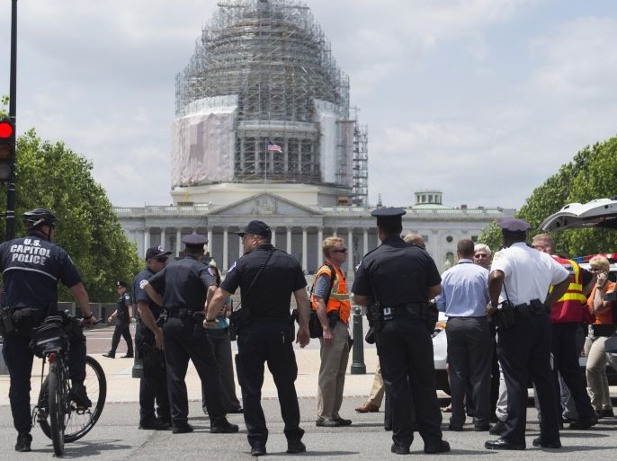 Police and other officials stand outside the US Capitol and the Capitol Visitor Center after the building was evacuated due to reports of a fire in Washington, DC, May 26, 2015. No smoke or fire were found and people were allowed to re-enter. AFP PHOTO / SAUL LOEB