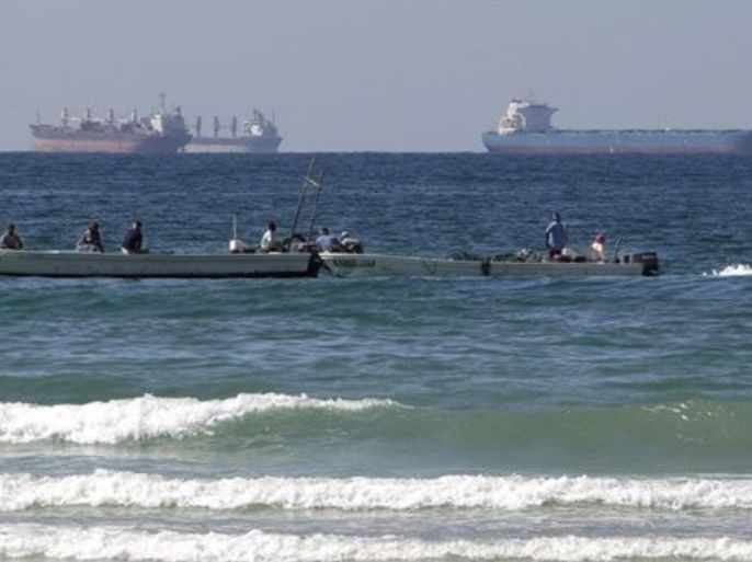 In this Jan. 19, 2012 photo, fishing boats are seen in front of oil tankers on the Persian Gulf waters, south of the Strait of Hormuz, offshore the town of Ras Al Khaimah in United Arab Emirates. Even as sanctions squeeze Iran ever tighter, there's one clandestine route that remains open for business: A short sea corridor connecting a rocky nub of Oman with the Iranian coast about 35 miles (60 kilometers) across the Gulf.