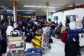Passengers wait at the check-in at Tripoli's militia-controlled Mitigia Airport, as flights were resumed, after planes from the internationally recognised air force struck the airport without causing any casualties on March 3, 2015. The attack on the airport was in response to militia warplanes launching an offensive on a major oil export terminal. AFP PHOTO / MAHMUD TURKIA