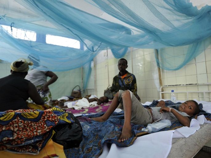 Parents sit next to their sick children laying on beds with mosquito nets in a hospital on April 24, 2015 in the popular suburb of Port-Bouet in Abidjan, on the eve of the World Malaria Day on April 25, 2015 as the Ivory Coast's ministry of Health in collaboration with the UNICEF and Global Fund for HIV launched in Abidjan a distribution of mosquito net in the prevention of the desease. Malaria kills on average 7 children every hour in Ivory Coats and about 1,200 children in sub-Saharan Africa per day. AFP PHOTO/ SIA KAMBOU