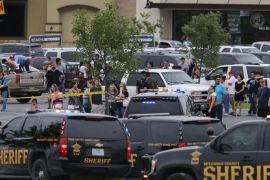 People at the Central Texas MarketPlace watch a crime scene near the parking lot of a Twin Peaks restaurant Sunday, May 17, 2015, in Waco, Texas. Waco Police Sgt. W. Patrick Swanton told KWTX-TV there were "multiple victims" after gunfire erupted between rival biker gangs at the restaurant. (Rod Aydelotte/Waco Tribune-Herald via AP)