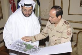 Egypt's army chief Field Marshal Abdel Fattah al-Sisi (R) looks at drawings of houses with Hasan Ismaik, Arabtec's chief executive, at the Ministry of Defence in Cairo in this March 9, 2014 handout provided by Egypt's Ministry of Defence. Arabtec Holding, Dubai's largest listed construction firm, has agreed with the Egyptian army to build one million houses in a project worth 280 billion Egyptian pounds, it said in a statement on Sunday. Picture taken March 9, 2014. REUTERS/Ministry of Defence/Handout via Reuters (EGYPT - Tags: BUSINESS CONSTRUCTION MILITARY POLITICS REAL ESTATE) ATTENTION EDITORS - THIS IMAGE HAS BEEN SUPPLIED BY A THIRD PARTY. FOR EDITORIAL USE ONLY. NOT FOR SALE FOR MARKETING OR ADVERTISING CAMPAIGNS. NO SALES. NO ARCHIVES. IT IS DISTRIBUTED, EXACTLY AS RECEIVED BY REUTERS, AS A SERVICE TO CLIENTS