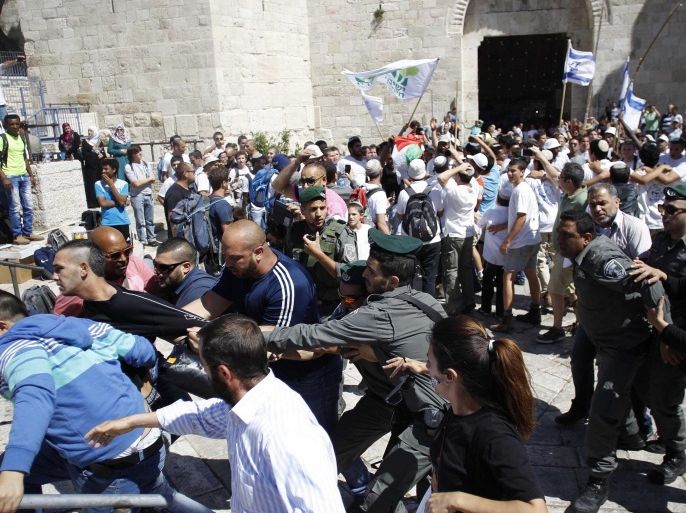 JERUSALEM - MAY 17: Israeli police interfere to Palestinians as a group of Jewish settlers forced their way into Al-Aqsa Mosque compound in occupied East Jerusalem as they mark 'Jerusalem Day' in Jerusalem on May 17, 2015. Israelis celebrate 17th of May as Jerusalem Day to mark their invasion of east Jerusalem anniversary occurred on the year 1967.