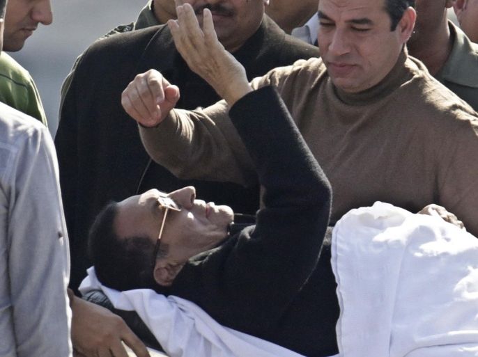 Former Egyptian President Hosni Mubarak, 86, greets medics, army personnel and his supporters, as he leaves a helicopter ambulance after it landed at Maadi Military Hospital following his verdict in Cairo, Egypt, Saturday, Nov. 29, 2014. An Egyptian court on Saturday dismissed criminal charges against former president Hosni Mubarak in connection with the killing of protesters in the 2011 uprising that ended his nearly three-decade reign. (AP Photo/Amr Nabil)