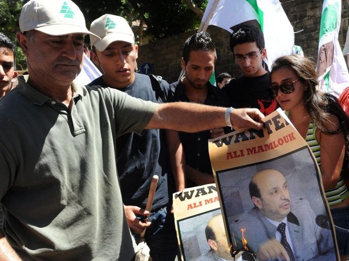 Supporters of the Kataeb party burn a placard with an image of General Ali Mamlouk, a top Syrian security official, during a protest in front of the Lebanese Ministry of Foreign Affairs, in the Ashrafieh neighborhood in Beirut, Lebanon, 22 August 2012. The protesters were denouncing the ministry's policy towards alleged Syrian cross-border raids into Lebanon, according to reports.