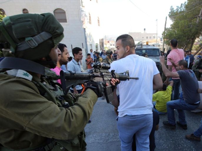 Israeli soldiers attempt to breakup a sit-in by Palestinians in the village of Kafr Malik, northeast of Ramallah on June 14, 2015, after clashes that resulted in the death of 21-year-old Palestinian Abdallah Ghanayem. An army spokesman told AFP that the Palestinian had died after he threw an incendiary device at a jeep and the vehicle overturned on him. Palestinian security sources said, Israeli soldiers killed Ghanayem by hitting him with their jeep during clashes near Ramallah in the occupied West Bank. AFP PHOTO / ABBAS MOMANI