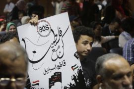 An Egyptian raises a poster with the Boycott, Divestment and Sanctions (BDS) logo and Arabic that reads, "we are all with Palestine, boycott Israel," during the launch of the Egyptian campaign that urges boycott, divestment and sanctions against Israel and Israeli-made goods, at the Egyptian Journalists’ Syndicate in Cairo, Egypt, Monday, April 20, 2015. BDS is a global movement initiated by Palestinian civil society activists in 2005 that organizers say will continue until Israel complies with international law and respects Palestinian rights. (AP Photo/Amr Nabil)