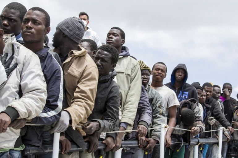 FILE - In this Sunday, May 31, 2015 file photo, migrants wait to disembark from the Italian Coast Guard ship Peluso, on the tiny Italian island of Lampedusa. Around 75,000 migrants have been picked up trying to enter Italy and Greece from Libya so far this year. More than 1,800 are feared to have died. Most rescue emergencies happen some 40 nautical miles from Libya. (AP Photo/Mauro Buccarello, File)