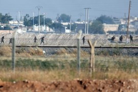 In this photo taken from the Turkish side of the border between Turkey and Syria, in Akcakale, southeastern Turkey, Kurdish fighters advance in the outskirts of Tal Abyad, Syria, Monday, June 15, 2015. Kurdish fighters captured large parts of the strategic border town of Tal Abyad from the Islamic State group Monday, dealing a huge blow to the group which lost a key supply line for its nearby de facto capital of Raqqa, a spokesman for the main Kurdish fighting force said. (AP Photo/Lefteris Pitarakis)