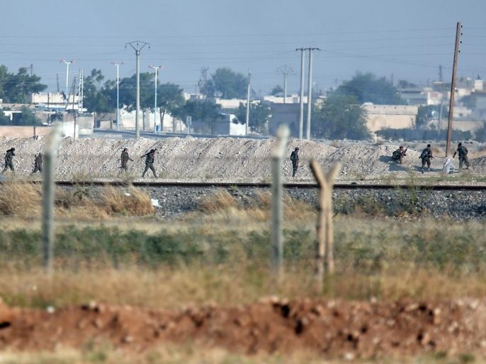In this photo taken from the Turkish side of the border between Turkey and Syria, in Akcakale, southeastern Turkey, Kurdish fighters advance in the outskirts of Tal Abyad, Syria, Monday, June 15, 2015. Kurdish fighters captured large parts of the strategic border town of Tal Abyad from the Islamic State group Monday, dealing a huge blow to the group which lost a key supply line for its nearby de facto capital of Raqqa, a spokesman for the main Kurdish fighting force said. (AP Photo/Lefteris Pitarakis)