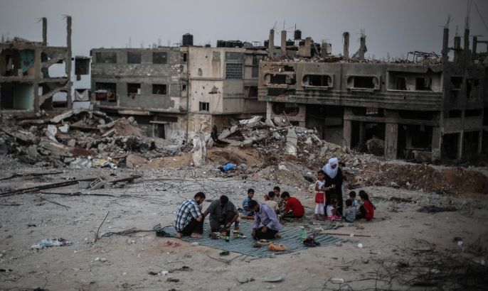 GAZA CITY, GAZA - JUNE 19: Muslim Palestinians break their fest amid the debris of buildings destroyed in the Israeli attacks in the Shajaiya neighborhood, Gaza Strip in Islam's holy fasting month of Ramadan on June 19, 2015.