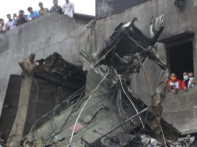 People view the wreckage of an Indonesian military C-130 Hercules transport plane after it crashed into a residential area in the North Sumatra city of Medan, Indonesia, June 30, 2015, in this photo taken by Antara Foto. More than 100 people were feared dead after the military transport plane ploughed into a residential area shortly after take-off in northern Indonesia on Tuesday, in what may be the deadliest accident yet for an air force with a long history of crashes. REUTERS/Irsan Mulyadi/Antara Foto ATTENTION EDITORS - THIS IMAGE HAS BEEN SUPPLIED BY A THIRD PARTY. IT IS DISTRIBUTED, EXACTLY AS RECEIVED BY REUTERS, AS A SERVICE TO CLIENTS. MANDATORY CREDIT. INDONESIA OUT. NO COMMERCIAL OR EDITORIAL SALES IN INDONESIA.
